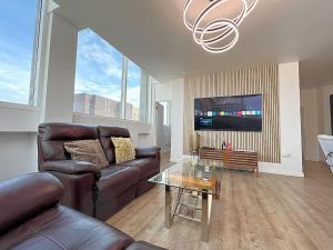 a living room with a couch and a table at The Penthouse Of Opulence in Birmingham