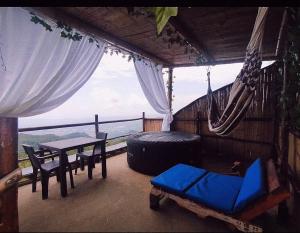 a room with a hammock and a table and a window at Cabañas Mirador La Roca in Melgar