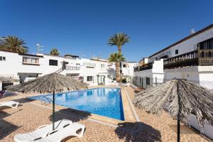- Piscina con 2 sombrillas y 2 sillas en Soul House Tenerife, en Costa del Silencio