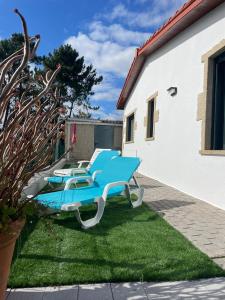 two blue and white lounge chairs sitting on the grass at Casa con vistas al mar in Noya