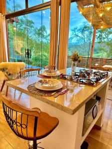 een keuken met een tafel met borden en glazen erop bij Chalé Tucano super Luxo in Cunha