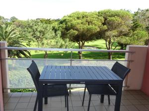 a blue table and chairs on a balcony with trees at Appartement 4 personnes entre mer et Golf à Anglet in Anglet