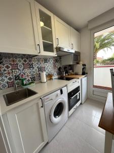 a kitchen with a washing machine and a sink at Apartamento con terraza en Mogro Playa de Usil in Mogro