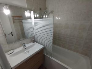 a bathroom with a sink and a mirror and a tub at Appartement 4 personnes entre mer et Golf à Anglet in Anglet +10 photos
