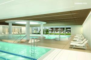 a swimming pool in a building with white chairs at Apartment in Pobierowo near Baltic Beach in Pobierowo