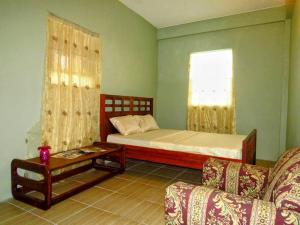 um quarto com uma cama, um sofá e uma janela em Herelle's Eden em Laborie
