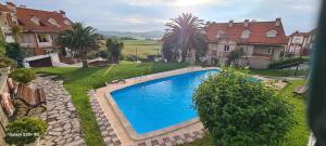 una piscina in un cortile accanto ad alcune case di Apartamento con terraza en Mogro Playa de Usil a Mogro