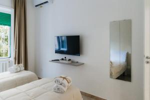 a hotel room with two beds and a tv at Zia Lulù apartment in Salerno
