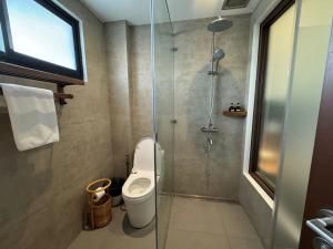 a bathroom with a toilet and a glass shower at Caracoa Resort in General Luna