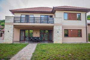 a house with a balcony and a patio at Relax Wellness Apartman Komlóska in Komlóska