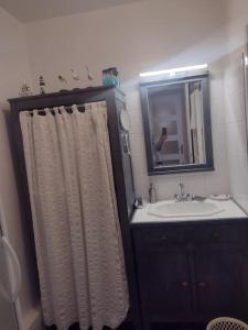 a bathroom with a sink and a shower curtain at Petit appartement - Quartier Vaugueux Château in Caen