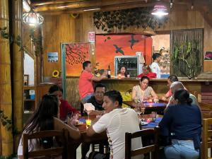 a group of people sitting at a table in a restaurant at WIPEOUT SUIT in Puerto López