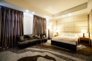 Habitación de hotel con cama y sofá en Absolute Hotel, en Astana