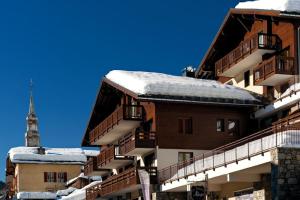 a apartment building with snow on the roof at Charmant T2 au cœur du village in Hauteluce