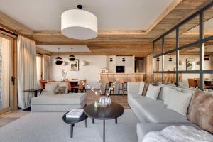 un soggiorno con un divano e un tavolo di Antarès MIRA 002 - prestige apartment ski inski out a Méribel