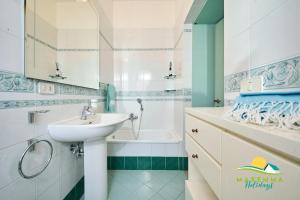a bathroom with a sink and a bath tub at Maremma Holidays Zot's Penthouse in Follonica +16 photos