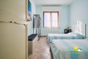 a hotel room with two beds and a window at Maremma Holidays Zot's Penthouse in Follonica