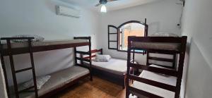 a room with three bunk beds and a window at Casa, Piscina, Sinuca Churrasqueira, Ping Pong, Praia Guarujá in Guarujá