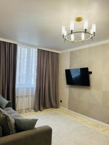 ein Wohnzimmer mit Sofa und Fernseher in der Unterkunft Двухкомнатная квартира in Taldykolʼ + 6 Fotos