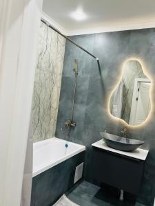 ein Badezimmer mit Waschbecken und Badewanne in der Unterkunft Двухкомнатная квартира in Taldykolʼ