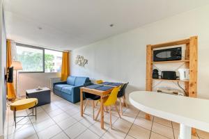 un salon avec une table et un canapé bleu dans l'établissement Apartment - 4P - Villeurbanne, à Villeurbanne