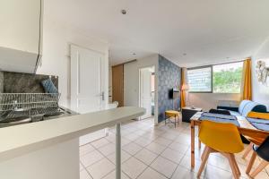 une cuisine et un salon avec une table et des chaises dans l'établissement Apartment - 4P - Villeurbanne, à Villeurbanne