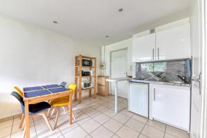 une cuisine avec des armoires blanches et une table et des chaises dans l'établissement Apartment - 4P - Villeurbanne, à Villeurbanne 3 autres photos