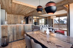 Un comedor con una gran mesa y sillas de madera. en Antarès MIRA 102 - luxury apartment ski inski out, en Méribel