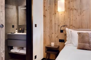 1 dormitorio con cama y lavamanos en Antarès MIRA 102 - luxury apartment ski inski out, en Méribel