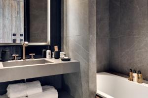 un baño con lavabo y bañera en Antarès MIRA 102 - luxury apartment ski inski out, en Méribel 12 fotos más