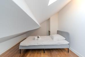 Un dormitorio con una cama con sábanas y almohadas blancas. en Maison Fontanières Studio Navarre 1 person, en La Mulatière