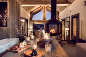 ein Wohnzimmer mit einem Kamin und einem Tisch mit Kerzen in der Unterkunft Antarès NAOS 501D - somptuous duplex penthouse luxury ski inski out in Méribel