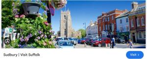 a town with a clock tower and a street with cars at Guest house paradiso in Great Cornard
