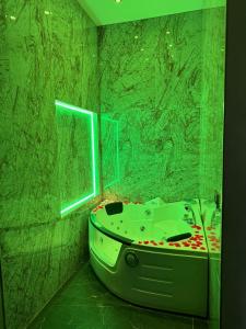 a green bathroom with a tub and a window at Gold House Roma in Rome