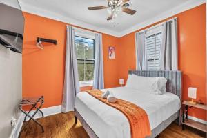 a bedroom with orange walls and a bed and a fan at Half Off SALE! Downtown Home with King Bed FirePit Free Parking and Huge Back Yard Filming Allowed in Wilmington