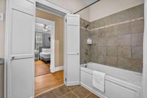 a bathroom with a bath tub and a shower at Half Off SALE! Downtown Home with King Bed FirePit Free Parking and Huge Back Yard Filming Allowed in Wilmington