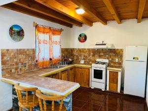 a kitchen with wooden cabinets and a white refrigerator at Cabañas Ojo de Agua in Mazamitla
