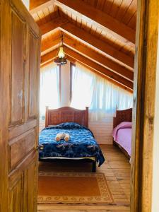 a bedroom with a bed in a wooden house at Cabañas Ojo de Agua in Mazamitla