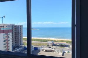 a view of the ocean from a window at Praia de Itaparica - Frente mar! Totalmente Montado! Até 5 hóspedes in Vila Velha