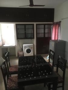 een eetkamer met een tafel en stoelen en een wasmachine bij HERITAGE TOWN Ac room for 2 in Pondicherry