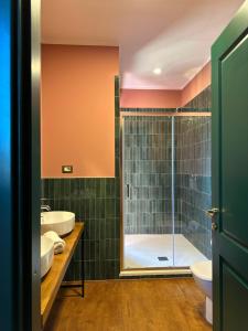 Olympia Resort & Spa في تاركوينيا: حمام مع مغسلتين ودش