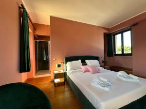 Olympia Resort & Spa في تاركوينيا: غرفة نوم مع سرير أبيض كبير مع وسائد وردية +4 صور