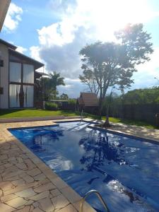 a swimming pool in a yard with a house at Casa de Campo Lazer Conforto e Wi Fi in Campo Limpo Paulista