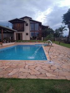 a house with a swimming pool in front of a house at Casa de Campo Lazer Conforto e Wi Fi in Campo Limpo Paulista
