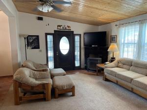 un soggiorno con un divano e una TV di Long Shot Cabin a Red River