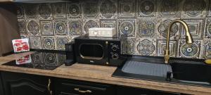 a kitchen counter with a microwave and a sink at VICTORIAN HOUSE in Sibiu