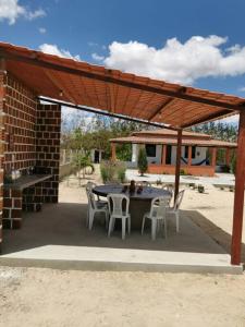 un patio con mesa y sillas bajo una pérgola en Rancho do Poeta - Chalé Umbucajá, en Lagoa Nova 9 fotos más