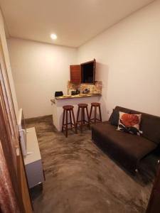 a living room with a couch and a bar at Rancho do Poeta - Chalé Umbucajá in Lagoa Nova +9 photos