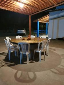 a wooden table and chairs on a patio at Rancho do Poeta - Chalé Umbucajá in Lagoa Nova
