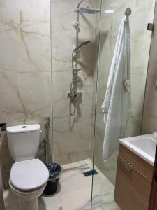 a bathroom with a toilet and a glass shower at Très belle appartement à louer sur bouznika de 117 m2 avec ascenseur in Bouznika +54 photos